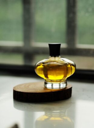 Frasco de perfume transparente com líquido amarelo