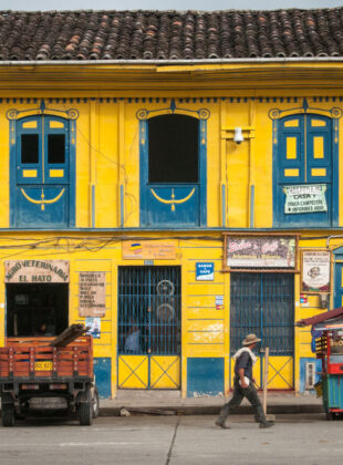 rua com sobrados coloridos com fachada de madeira pintada de amarelo e janelas azuis