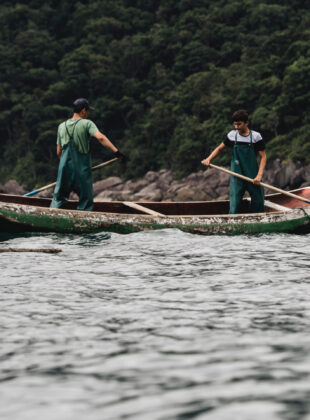 Dois pescadores remam em um barco no mar