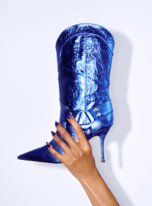 Modelo segura bota estilo cowboy em azul metalizado da marca Paris Texas